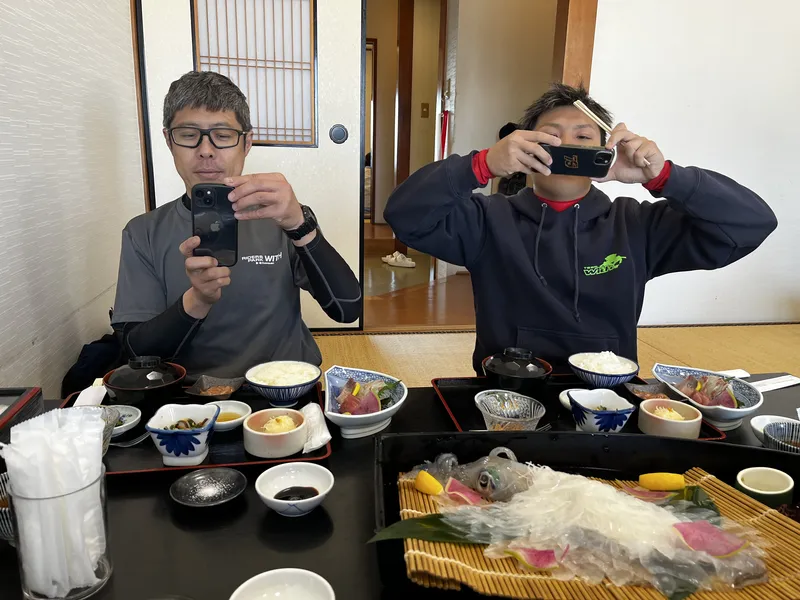 いかの活き造りの写真を撮っているスタッフたち